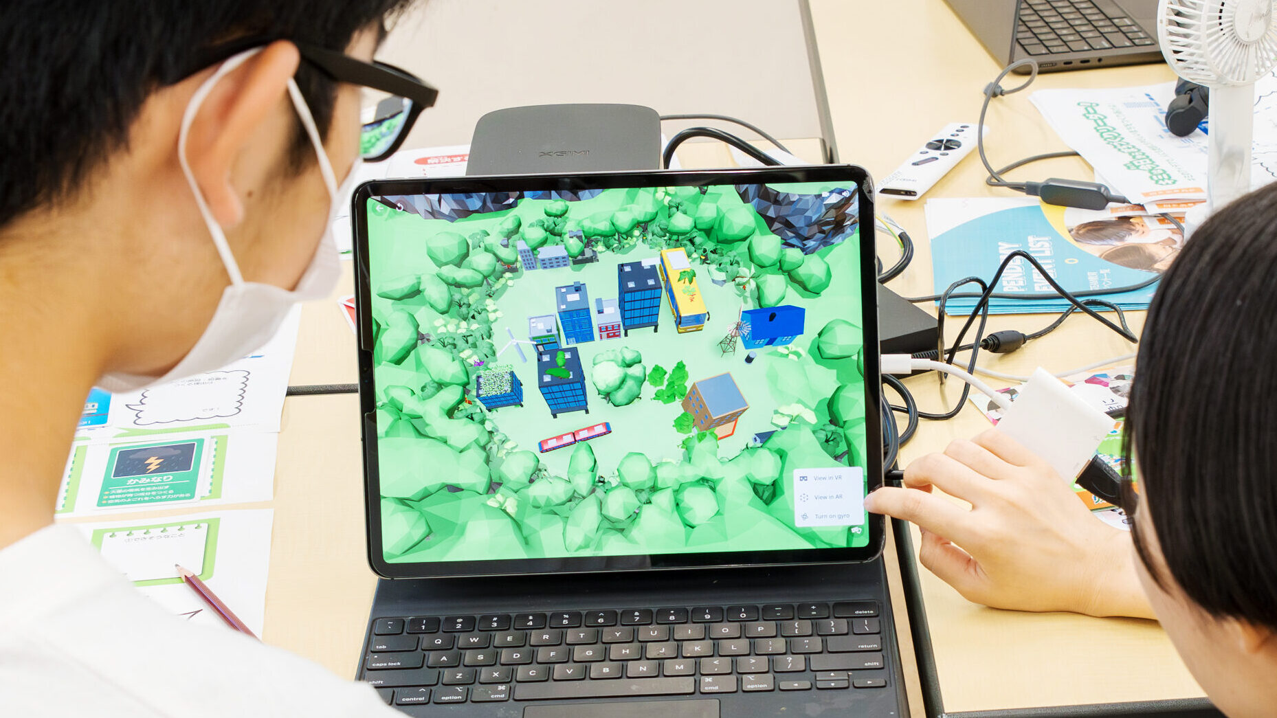 サステナブルなまちづくり教材「サスネタ！」で考えた企画を、パソコン上の3Dモデル（建物や緑地の配置）として可視化・検討するワークショップ風景