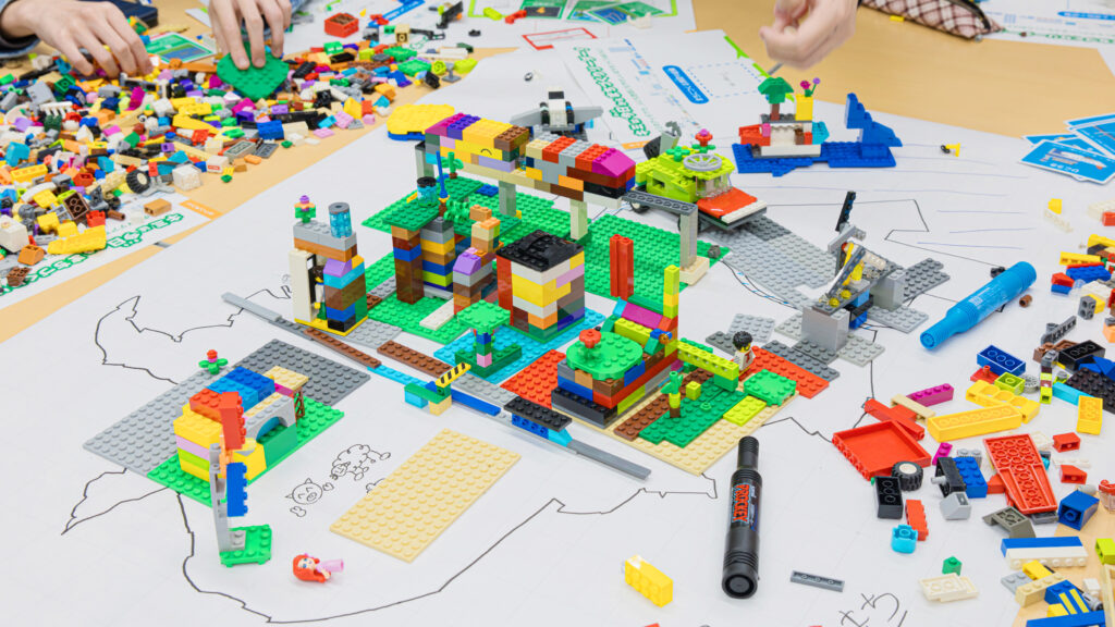 サステナブルなまちづくりワークショップ「サスネタ！」で、アイデアをLEGOブロックの都市模型（建物・緑地・設備）として形にしている制作風景