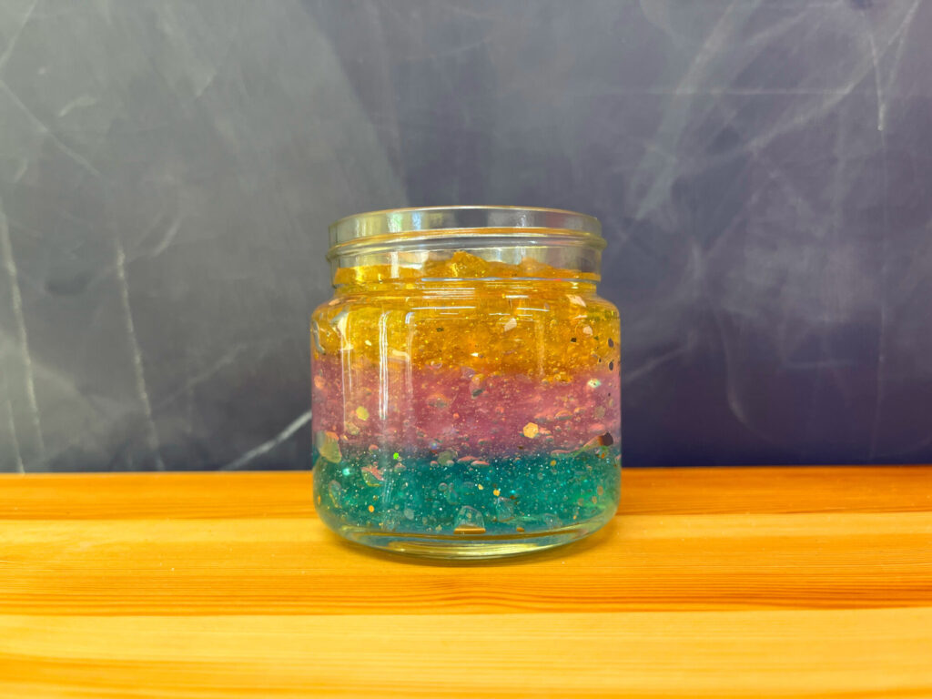 カラフルに層が分かれた手作り虫よけジェルの瓶。自由研究で人気の理科実験で色と質感を観察できる作品。