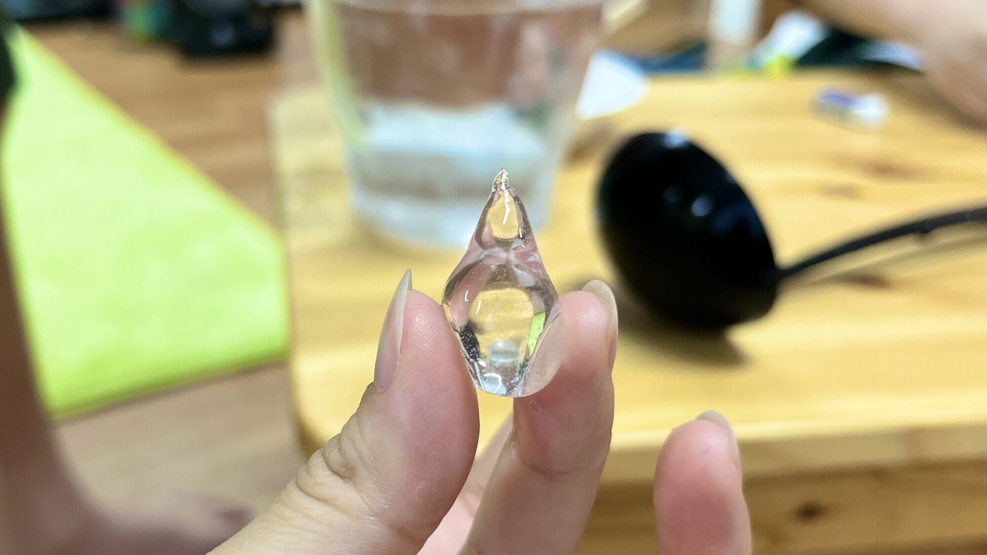 完成した透明でプルプルの掴める水（食べられる水）を摘んでいる様子。
雫の形。